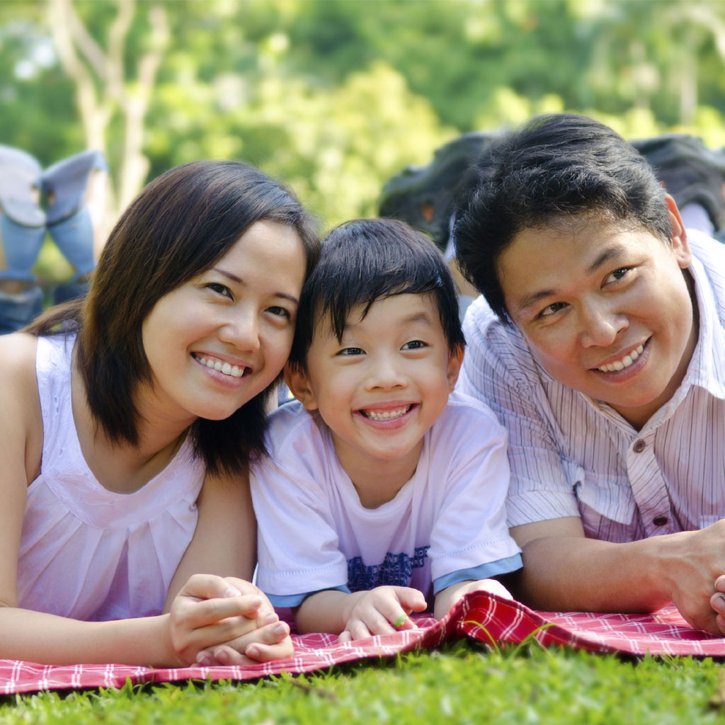 Smiling family laying on picnic blanket