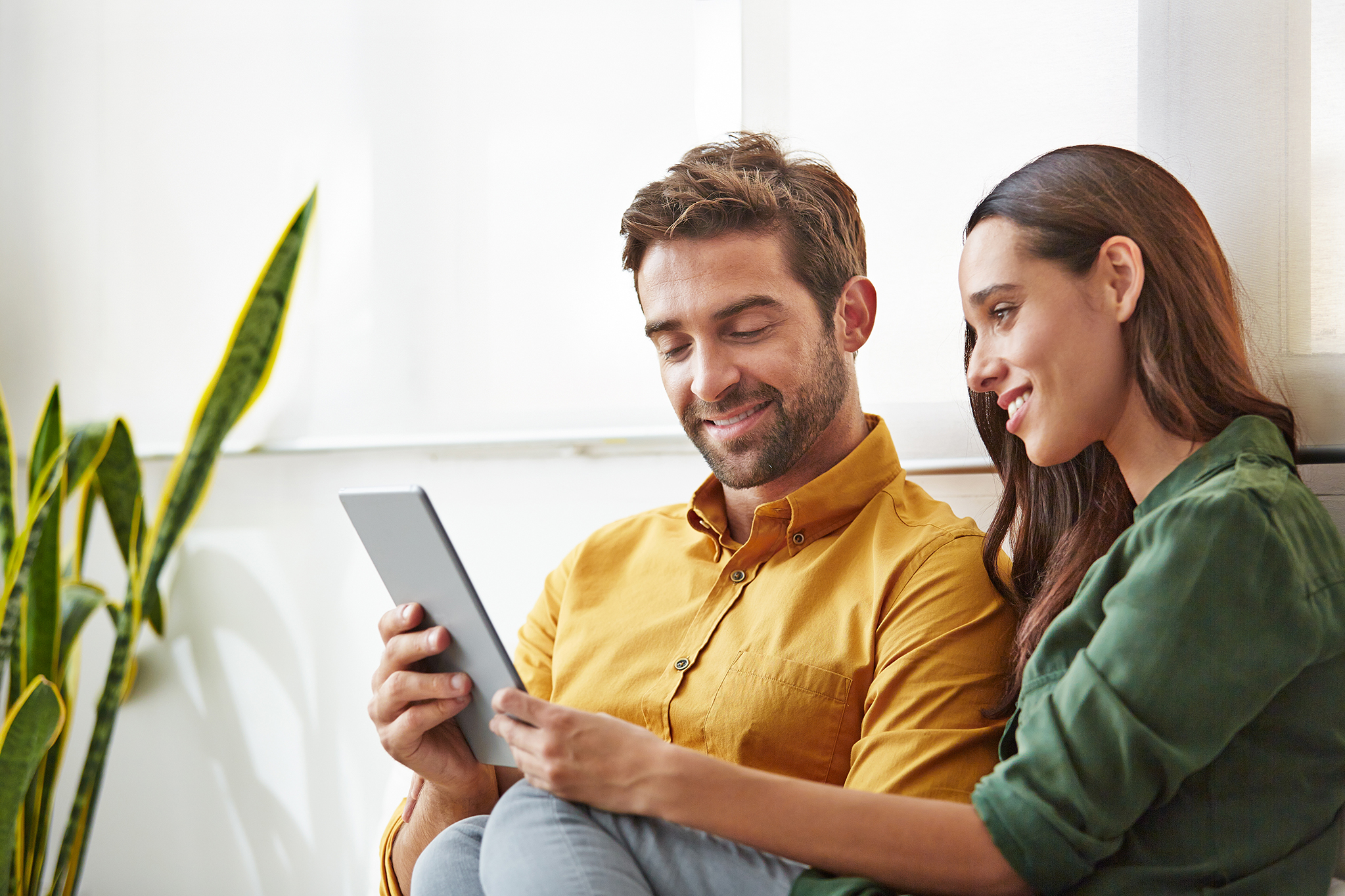Couple reading the Infertility Solutions magazine on a tablet